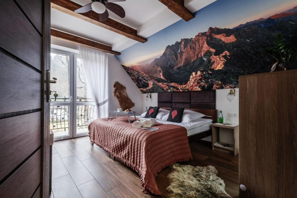 a bedroom with a bed with a mountain mural on the wall at SUMMIT-Szczawnica-Centrum in Szczawnica