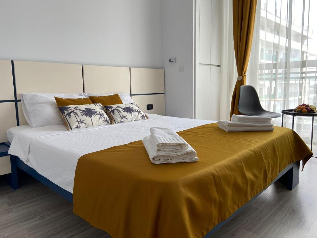 1 dormitorio con 1 cama con toallas en Summer breeze Studio - Onix Blue Mamaia Nord, en Mamaia Nord – Năvodari