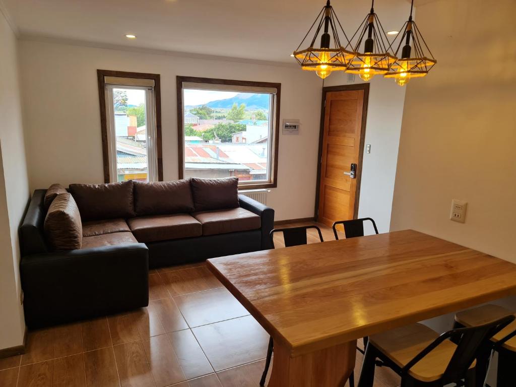 ein Wohnzimmer mit einem Sofa und einem Tisch in der Unterkunft Alto Balmaceda in Puerto Natales