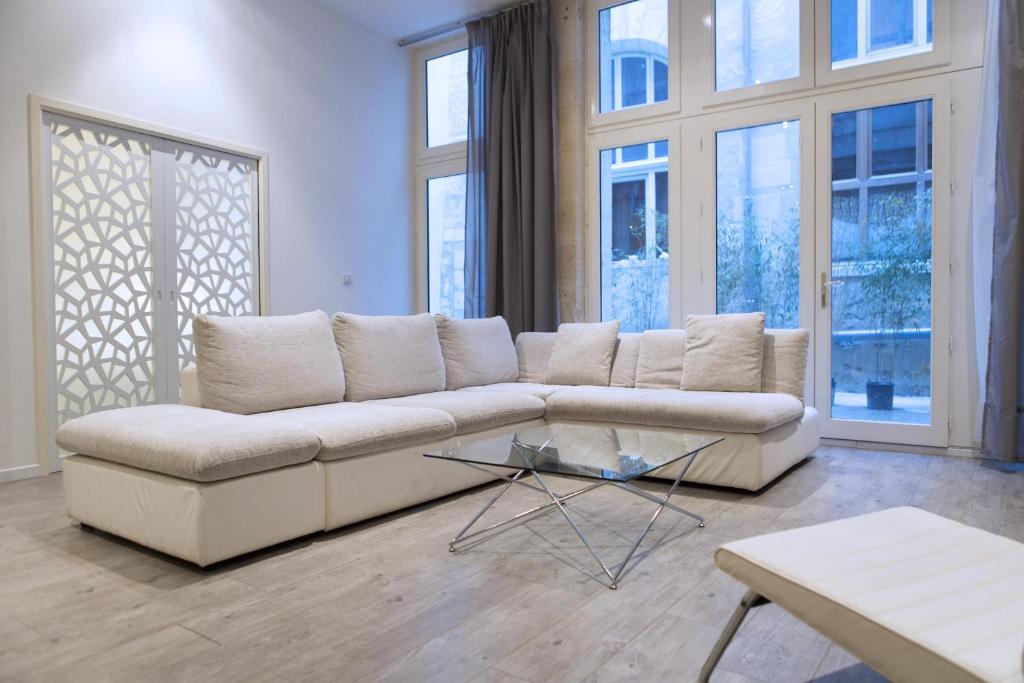 a living room with a couch and a glass table at Ausone Beautiful loft apartment in historical center + terrace and parking in Bordeaux