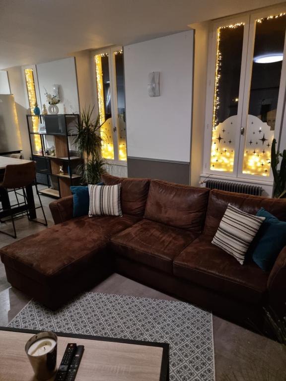 um sofá de couro castanho numa sala de estar em La Résidence M*C em Semur-en-Auxois