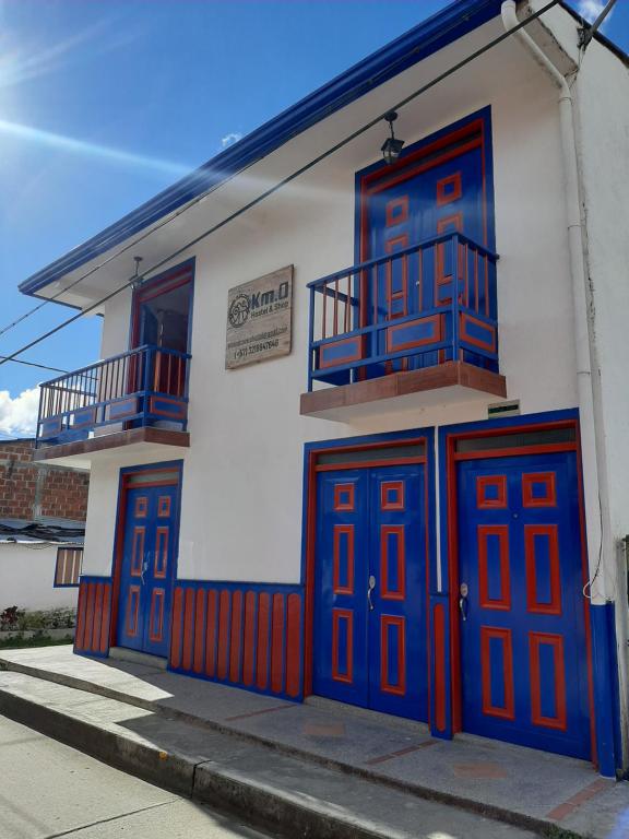 a building with red and blue doors on a street at Km0 Hostel in Salento