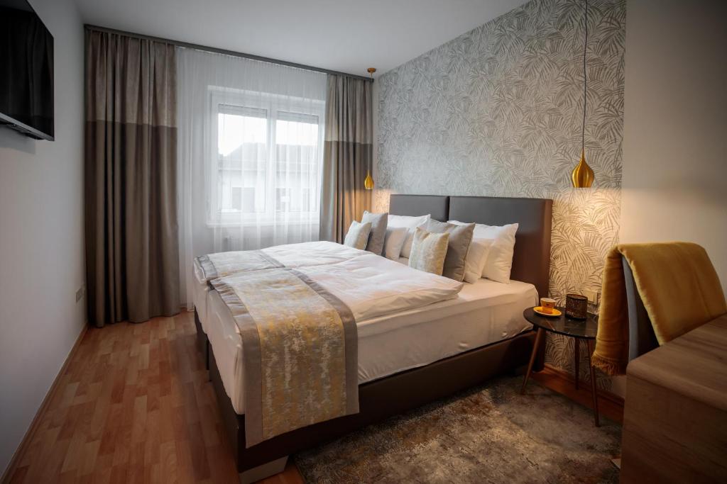 a bedroom with a large bed with a window at Mokka Best Apartments in Miskolc
