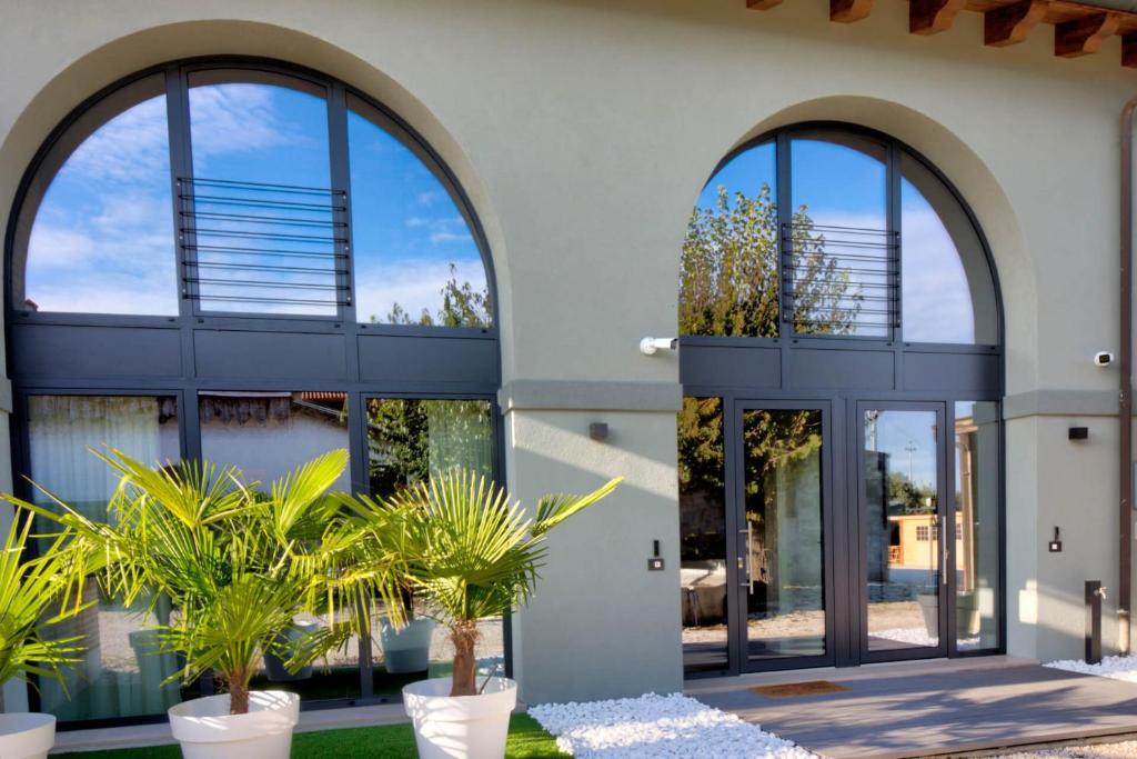 a house with large windows and plants in front of it at Nuovo B&B WhyNot? a Vicenza in Vicenza