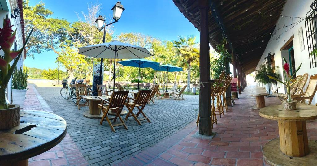 un patio al aire libre con mesas, sillas y sombrillas en Casa Portales de Santa Bárbara en Mompox