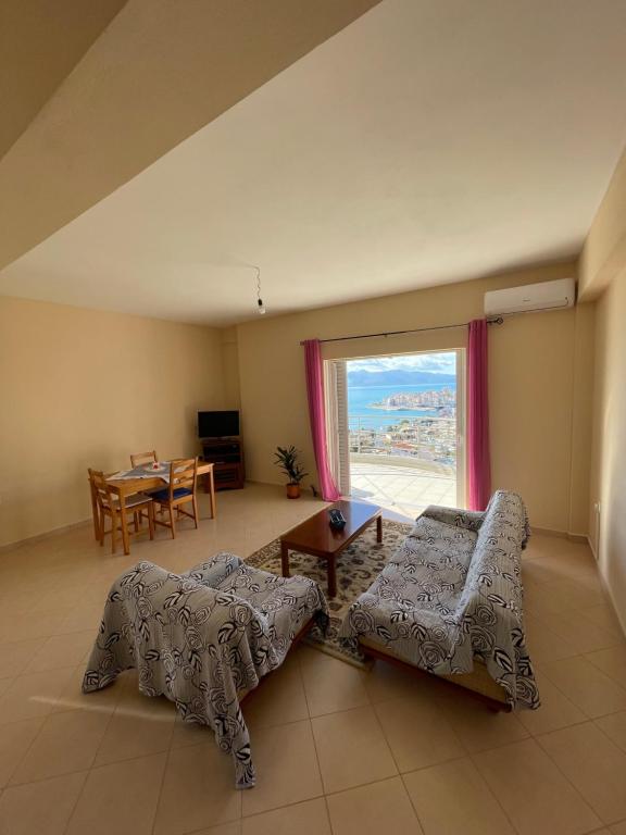 ein Wohnzimmer mit einem Sofa und einem Tisch in der Unterkunft L.T. Apartment 5th street in Sarandë