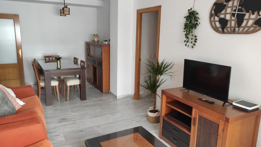 - un salon avec une télévision sur un centre de divertissement en bois dans l'établissement Apartamento La Marina, à Tarifa
