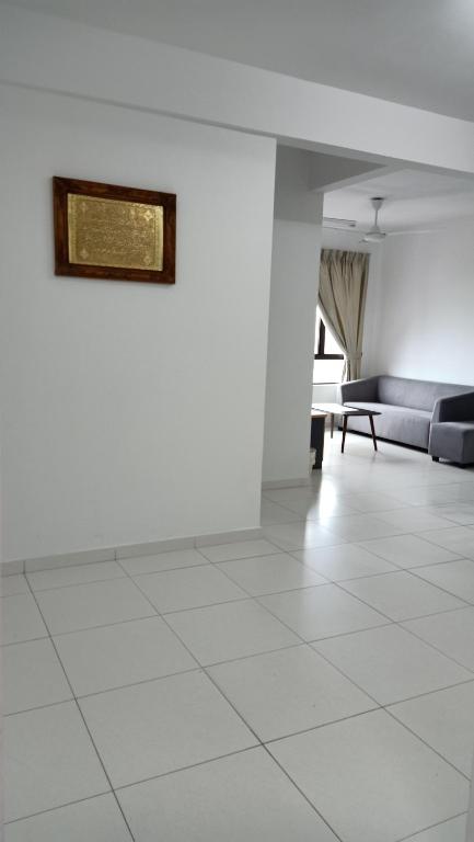 een woonkamer met een bank en een tegelvloer bij Hana Homestay The Heights Residence in Ayer Keroh