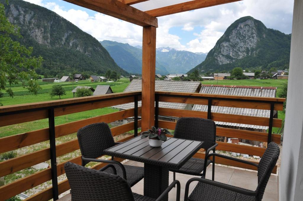 een tafel en stoelen op een balkon met uitzicht op de bergen bij Apartment Tina in Bohinj
