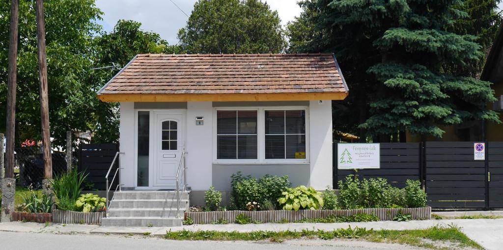 une petite maison avec un toit brun dans l'établissement Fenyves-lak, à Szalkszentmárton