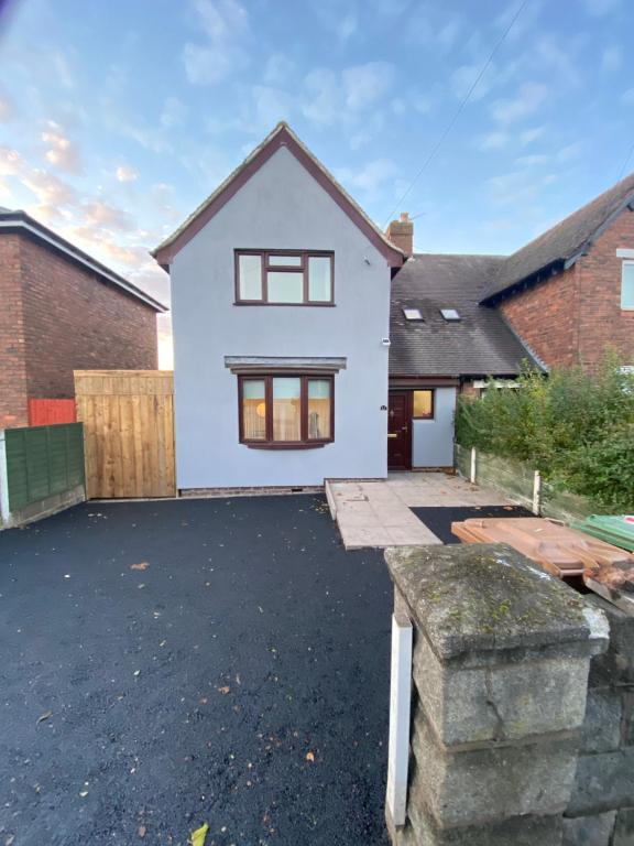 a white house with a driveway at Hollemeadow in Bloxwich