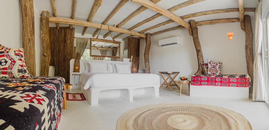 a bedroom with a bed and a couch at Éteka Slow Beach Hotel Adults Only in Cartagena de Indias