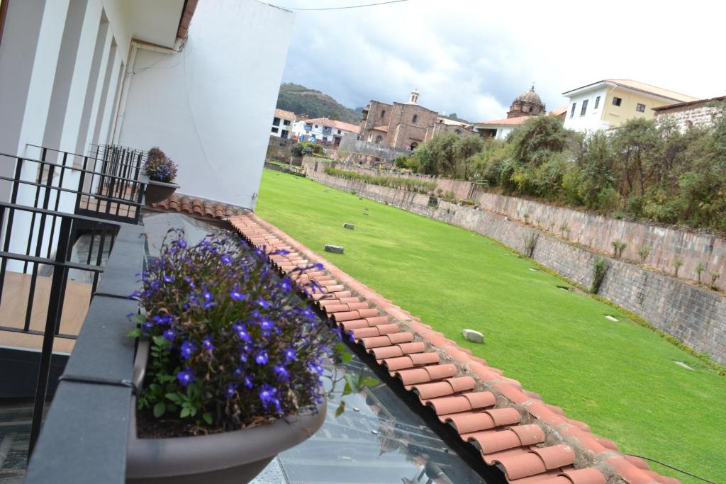 a balcony with a flower pot and a yard at Katari Apart Hotel at Qorikancha in Cusco