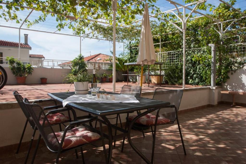 a table with chairs and an umbrella on a patio at Apartment Sve - with parking in Makarska