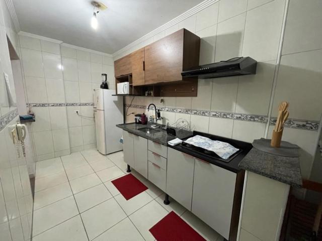 a kitchen with a counter top and a refrigerator at Apartamento aconchegante 1 quadra da praia in Praia Grande