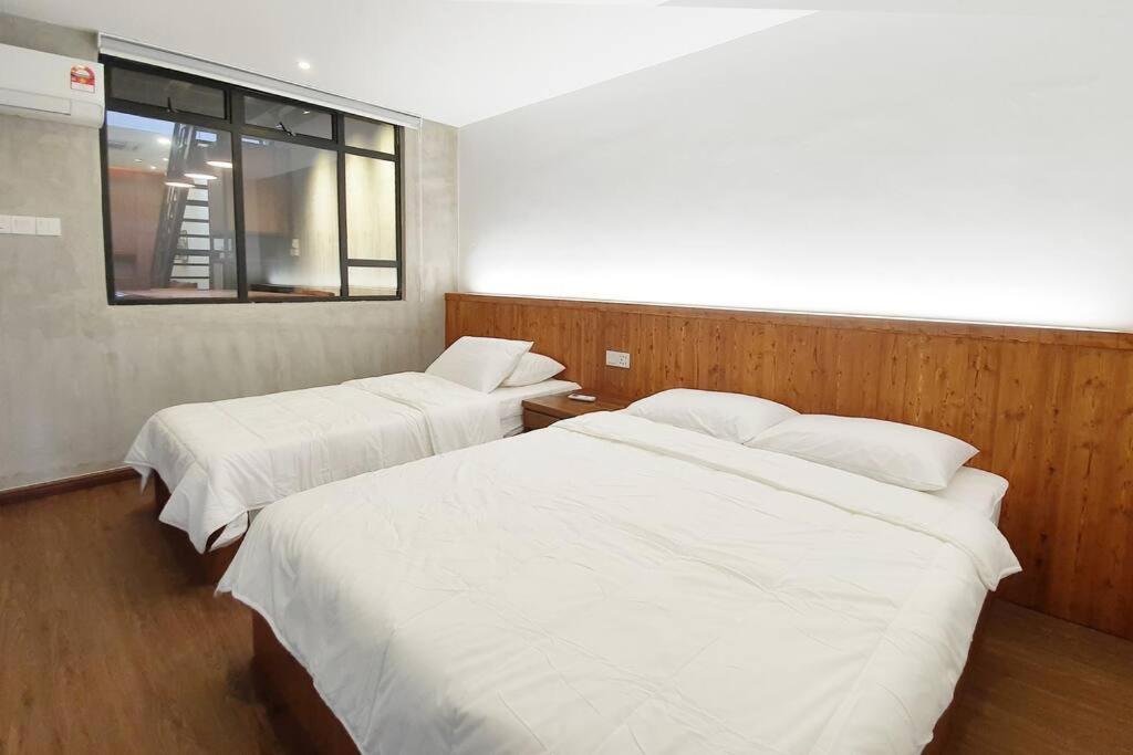 um quarto com duas camas e uma janela. em [New!] Jonker Street Loft 3BR Melaka 10PAX em Malaca