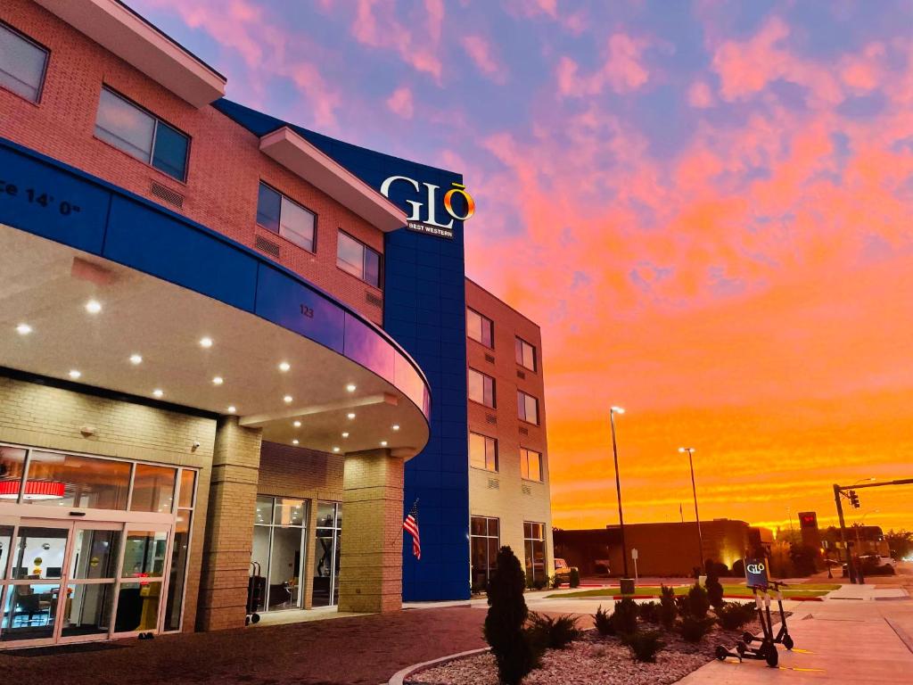 a woman walking in front of a building at GLō Best Western Enid OK Downtown - Convention Center Hotel in Enid