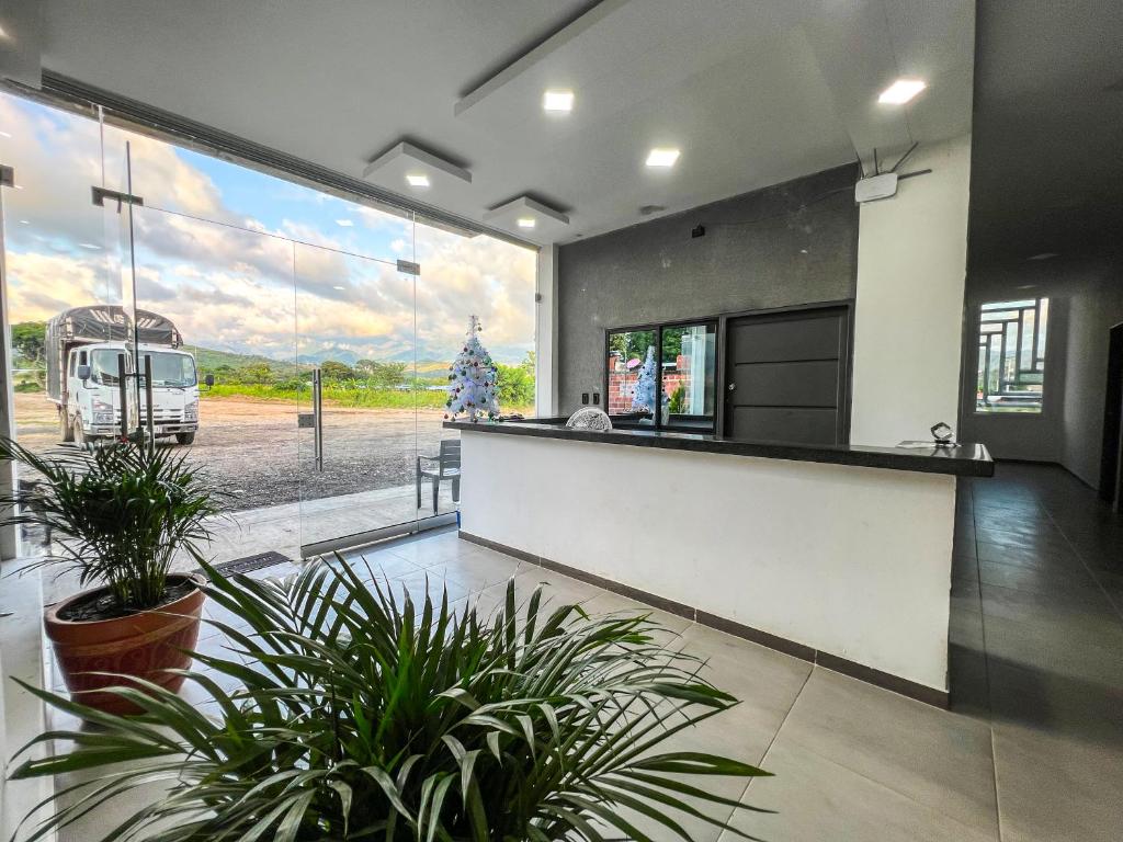 a kitchen with potted plants and a large window at Sagrado Hotel in Aguachica