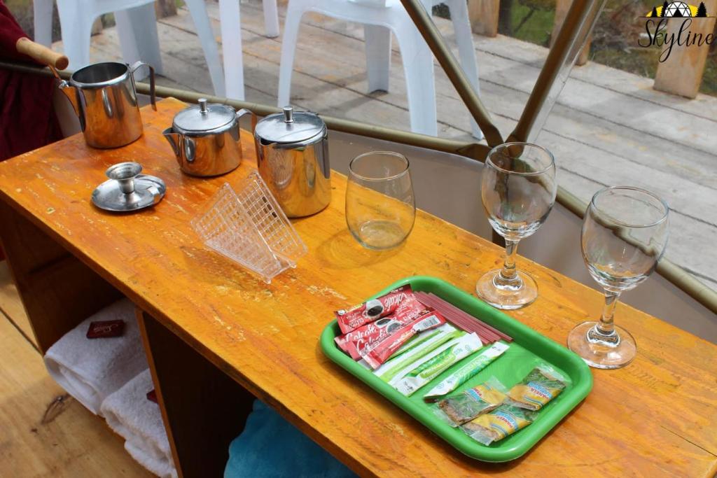 stół z kieliszkami do wina i tacą z jedzeniem w obiekcie Skyline Glamping Guasca w mieście Guasca