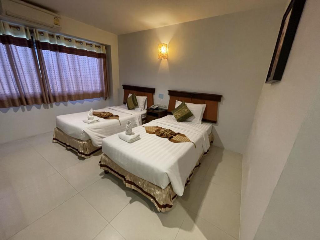 Postel nebo postele na pokoji v ubytování Chiangrai Grand Room Hotel