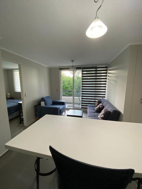 a white table and chairs in a living room at Condominio Robles camino al volcan in Pucón