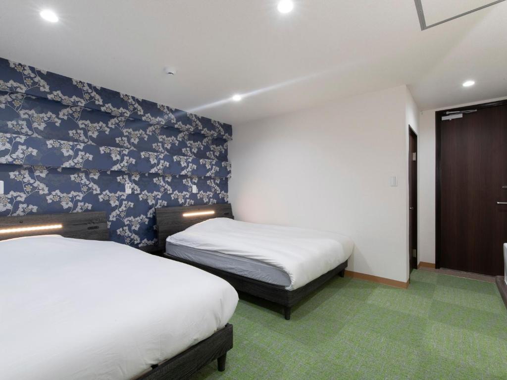 A bed or beds in a room at Tabist Hotel Miyakonojo Miyazaki