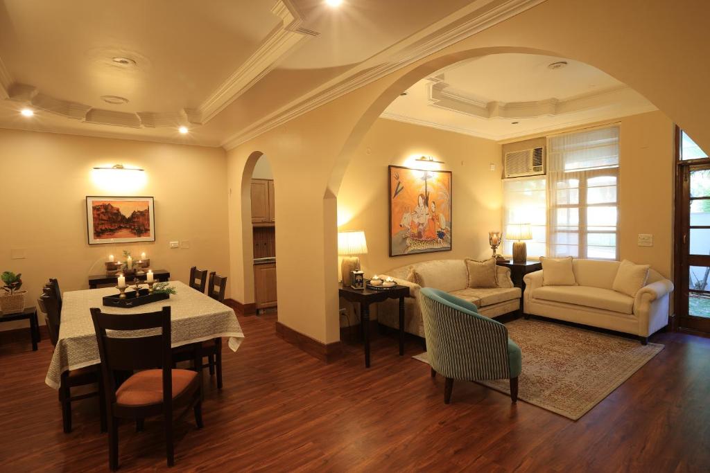 uma sala de estar com uma mesa e uma sala de jantar em Lamrin Boutique Cottages, Rishikesh em Rishikesh