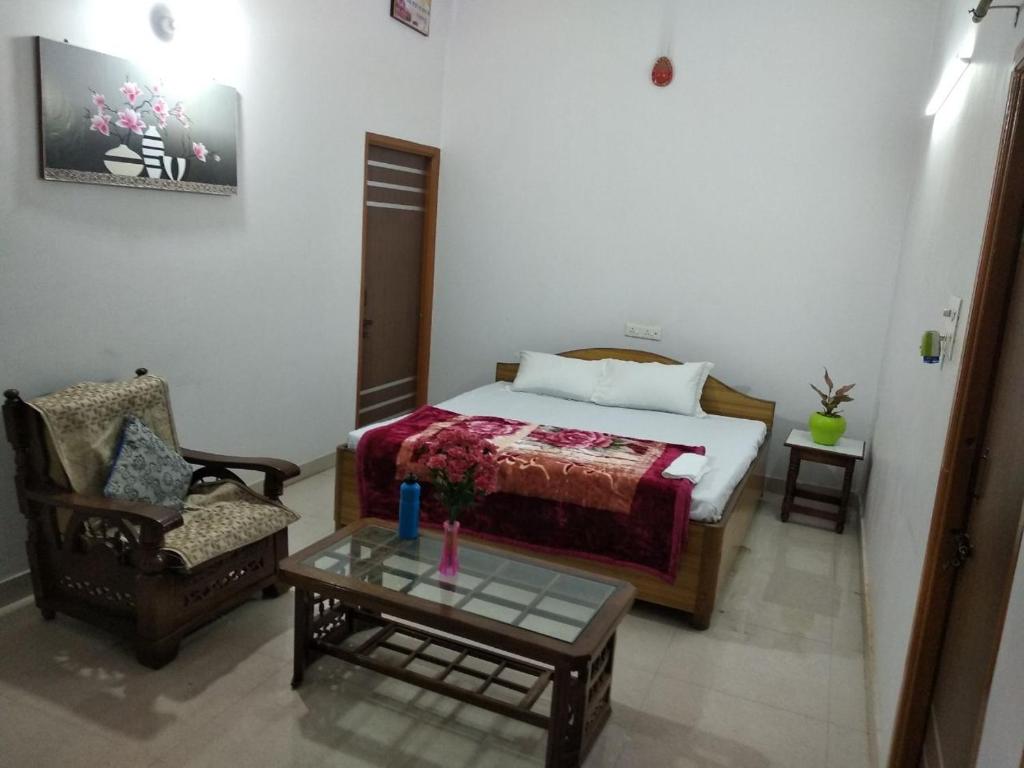 a bedroom with a bed and a chair and a table at Videep house in Kānpur