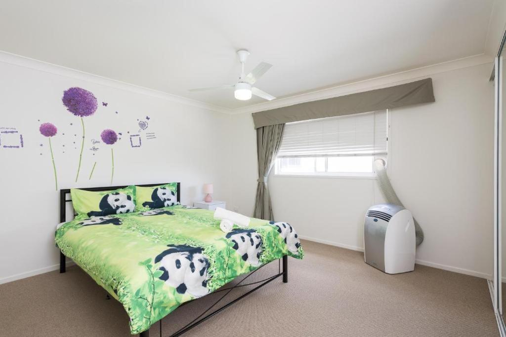 - une chambre avec un lit et une couette verte dans l'établissement 3 Bedroom Unit earlier check in Pet Friendly, à Buderim