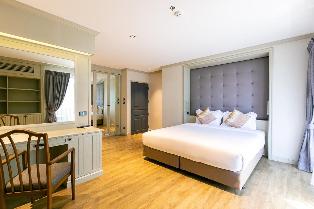 a bedroom with a bed and a desk and a chair at Thea, Executive Suite Serviced Apartment in Ekamai in Bangkok