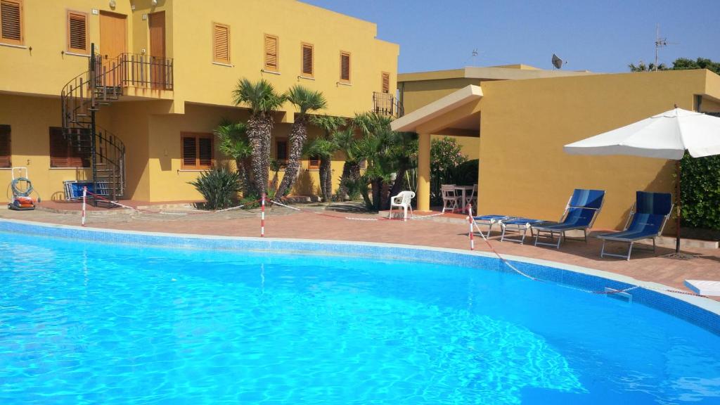 a large swimming pool in front of a building at Residence Covo degli Dei in Milazzo