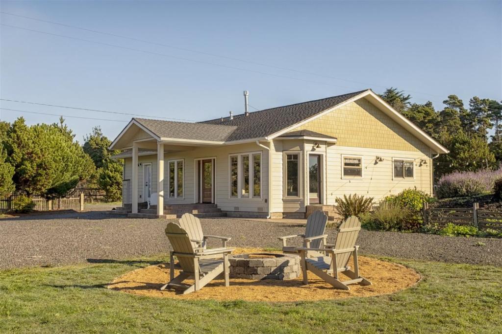 a house with three chairs in front of it at A - Paseo Del Mar in Fort Bragg