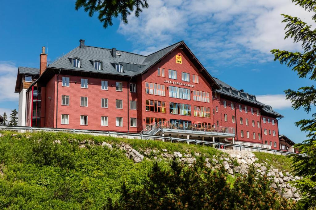 a large red building on top of a hill at JUFA Hotel Hochkar in Göstling an der Ybbs
