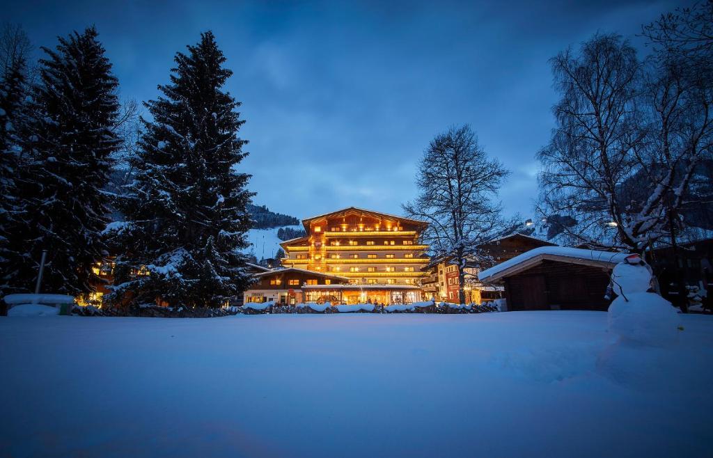 a large room with a snow covered cabin and trees at Hotel Glemmtalerhof in Saalbach-Hinterglemm
