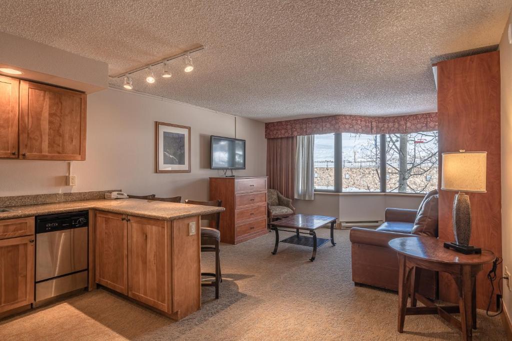 a kitchen and living room with a couch and a table at Grand Lodge 1-Bedroom Condo with 3 Queens & Close to Everything condo in Crested Butte