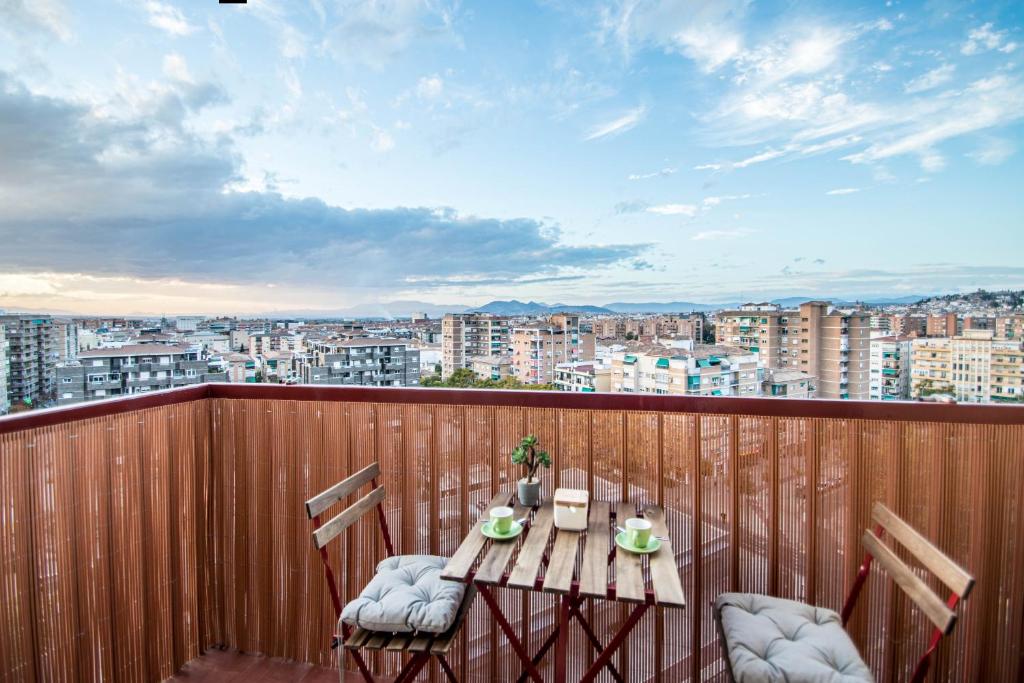 una mesa y sillas en un balcón con vistas en Hípica Apartment Granada by A3Rentals en Granada