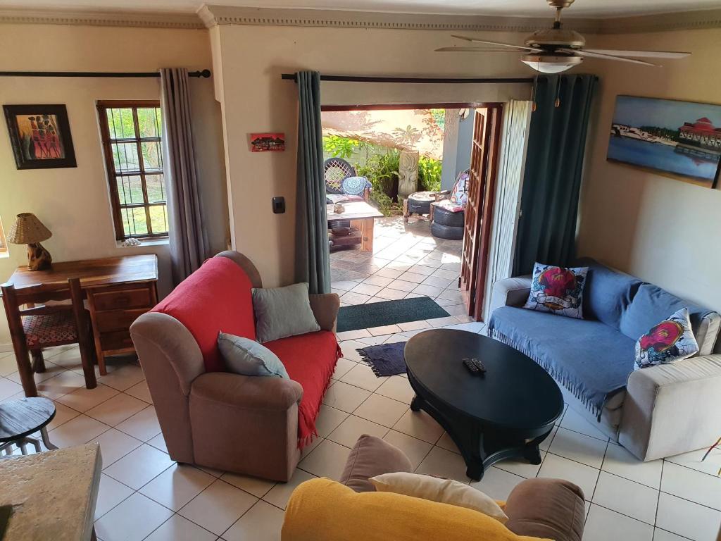 a living room with two couches and a table at Hacienda Holiday Home in Richards Bay