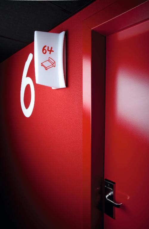 a red wall with a sign on it next to a door at Casa Camper Berlin in Berlin