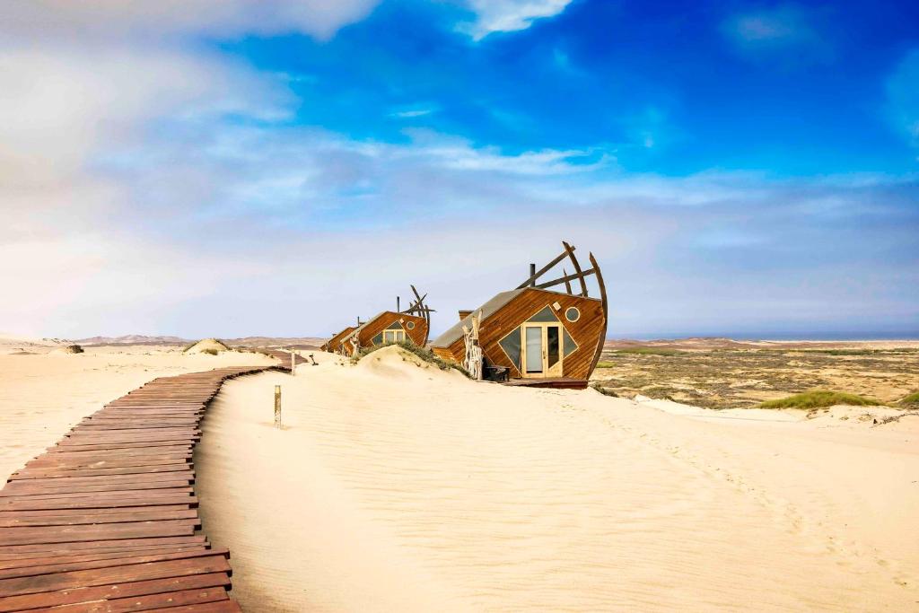 a house on the sand in the desert at Shipwreck Lodge in Möwebaai