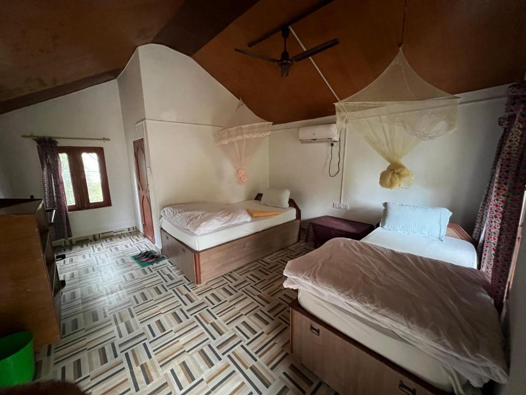 1 dormitorio con 2 camas en una habitación con techo en Bardia Wildlife Resort, en Bhurkīā