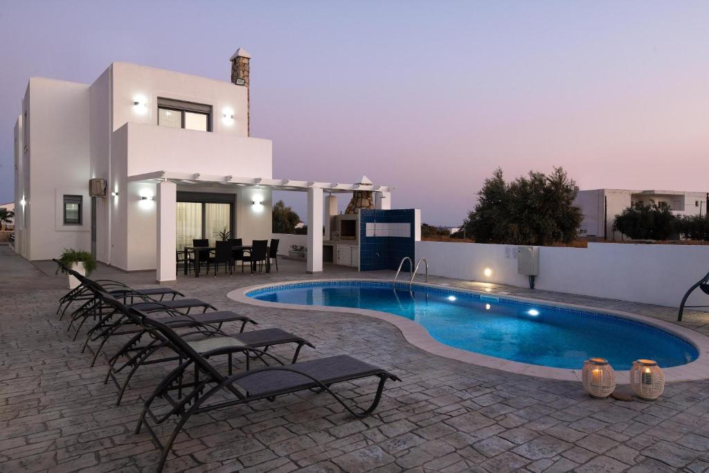 Villa mit einem Pool mit Stühlen und einem Haus in der Unterkunft Dama Dama Villas in Gennadi