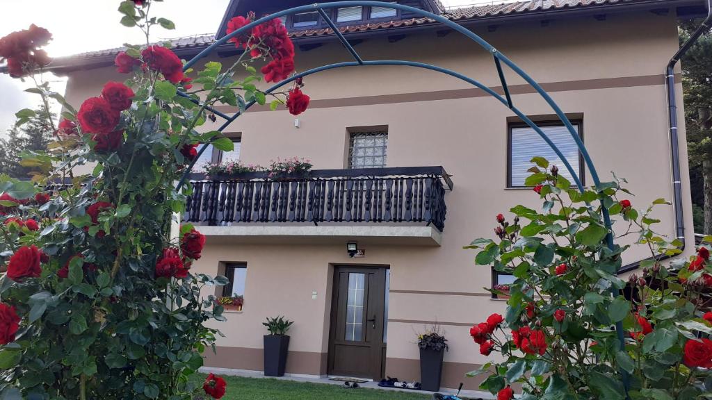 a house with a balcony and red roses at Apartment Panorama in Zreče