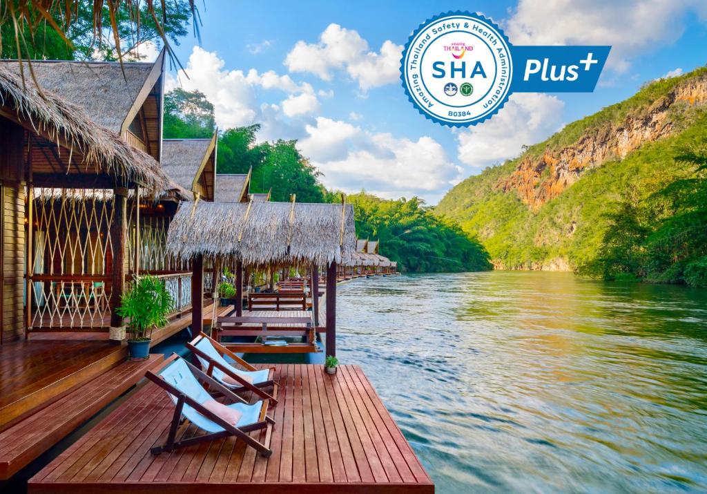 un muelle con sillas y un río con un cartel que dice shka plus en The Float House River Kwai - SHA Extra Plus en Sai Yok