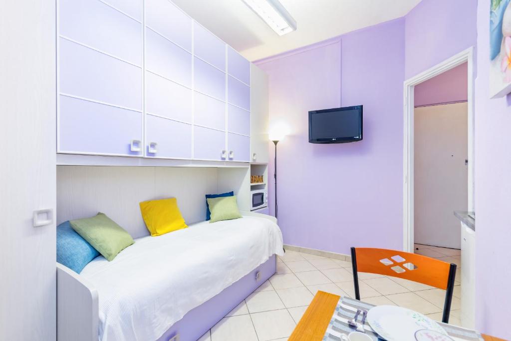 Schlafzimmer mit einem Bett mit gelben und blauen Kissen in der Unterkunft Studio Lavanda by Wonderful Italy in Turin