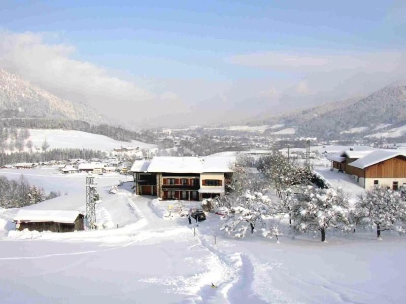 a house covered in snow in a snow covered village at Ferienwohnungen Plenk inkl. Chiemgaukarte in Ruhpolding