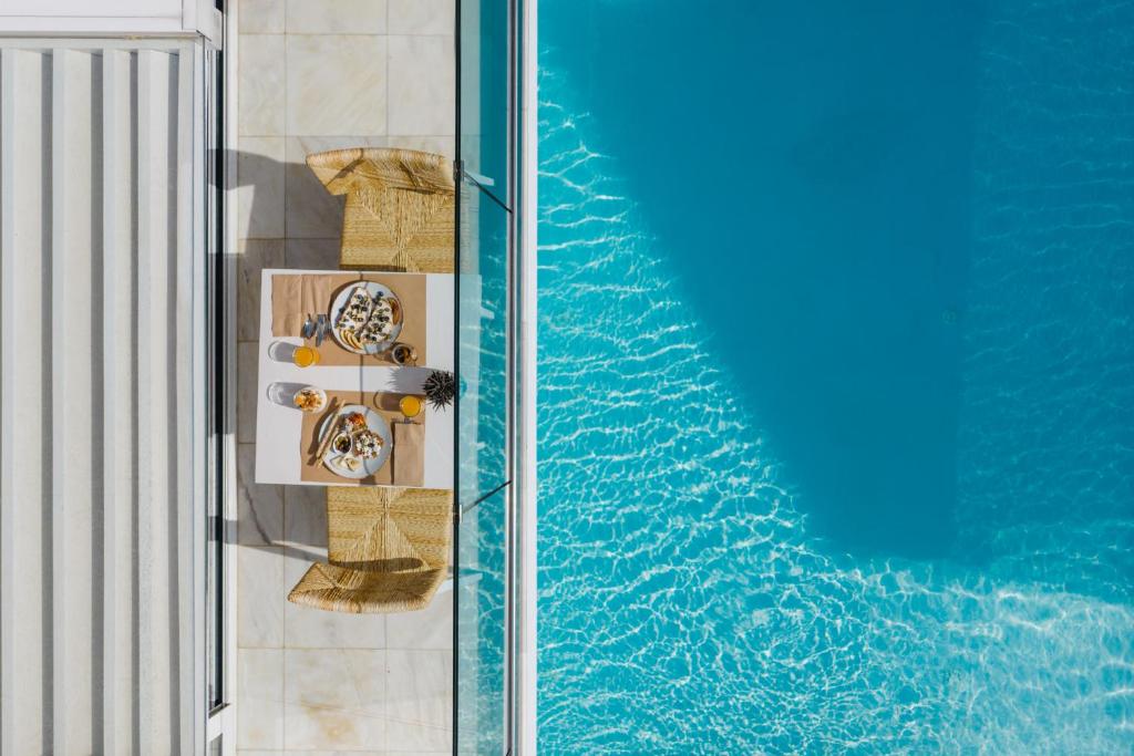 an overhead view of a swimming pool with a table and chairs at Cyano Hotel in Plakias