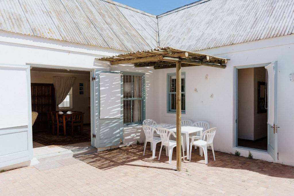 a table and chairs under an umbrella on a patio at In Betwix in Paternoster
