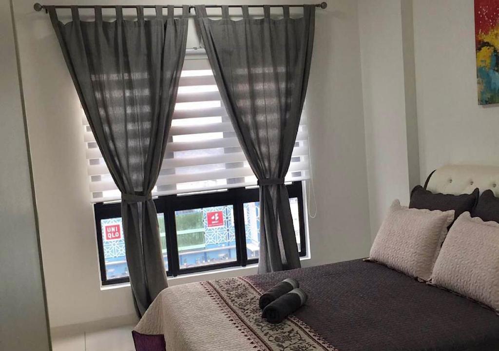 um quarto com uma cama e uma grande janela em Emira Residence Sek 13 Shah Alam Wi-Fi Netflix em Shah Alam