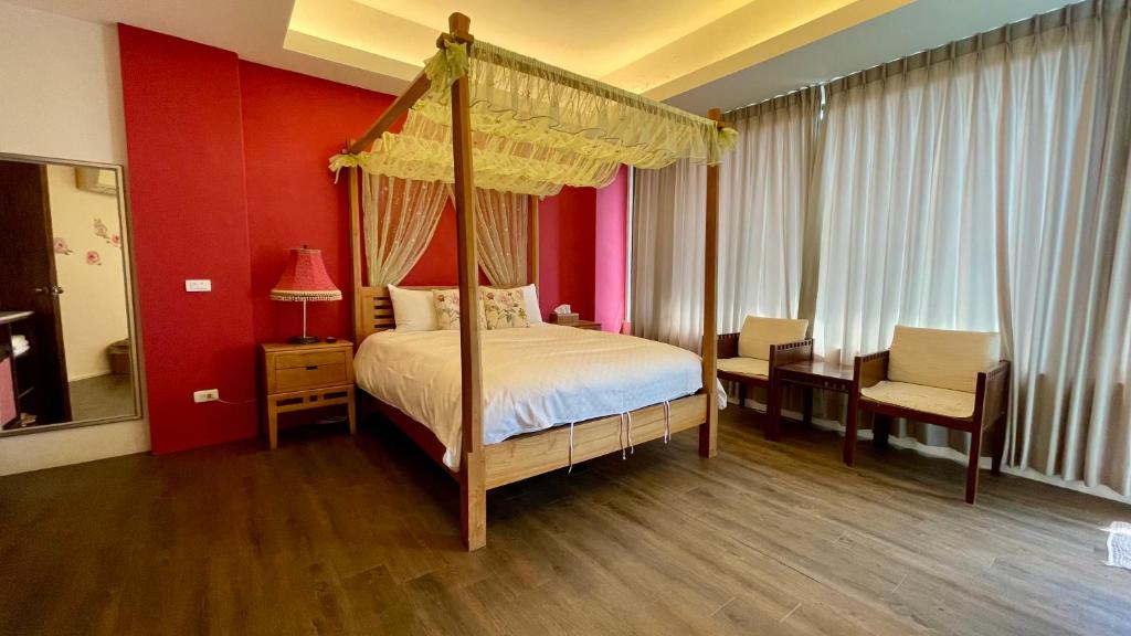 1 dormitorio con cama con dosel y escritorio en Rose Garden, en Hualien City
