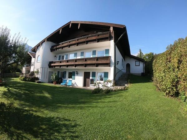 uma grande casa branca com um telhado de gambrel em Ferienwohnung Thann em Brannenburg